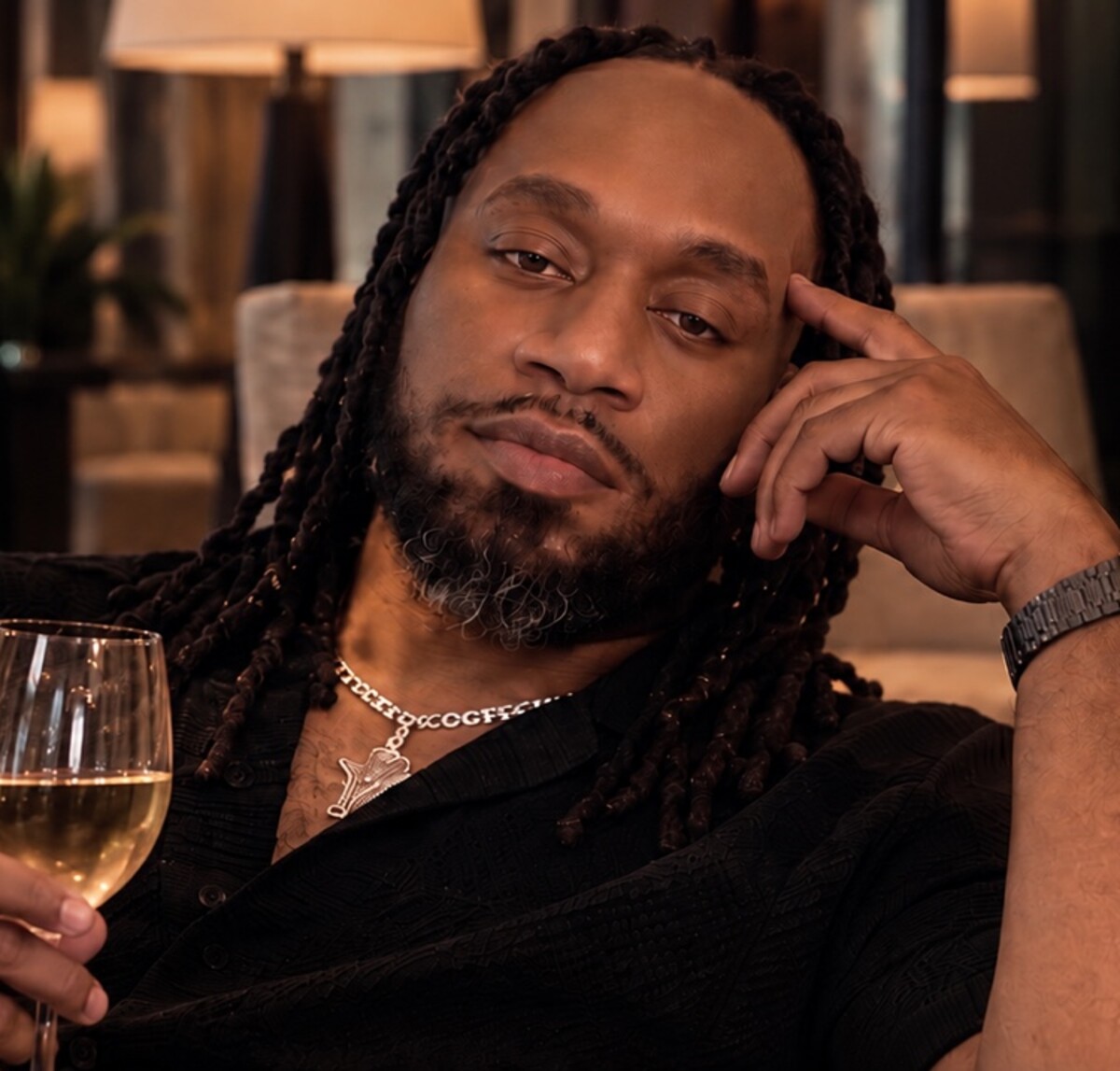 XSCAPES community member relaxing with a wine glass in an elegant lounge